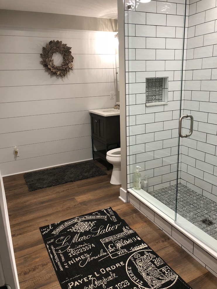 Idee per una stanza da bagno country con ante bianche, piastrelle bianche, piastrelle in ceramica, pavimento in vinile e pavimento marrone