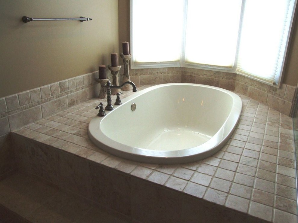 This is an example of a large classic ensuite bathroom in Cleveland with raised-panel cabinets, medium wood cabinets, tiled worktops, a built-in bath, beige tiles, ceramic tiles, brown walls and ceramic flooring.