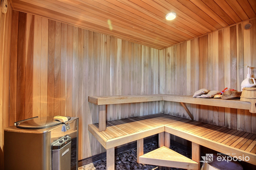 Cette image montre un sauna traditionnel de taille moyenne avec des portes de placard blanches, une baignoire d'angle, des carreaux de porcelaine et un sol en galet.