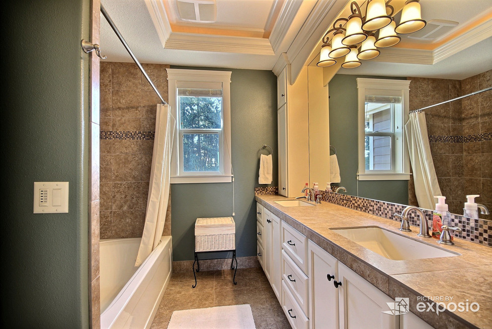 Example of a mid-sized transitional brown tile and ceramic tile travertine floor bathroom design in Portland with furniture-like cabinets, white cabinets, a two-piece toilet, green walls, a vessel sink and tile countertops