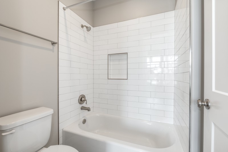 Inspiration for a mid-sized craftsman gray tile brown floor bathroom remodel in Salt Lake City with recessed-panel cabinets, brown cabinets and white walls