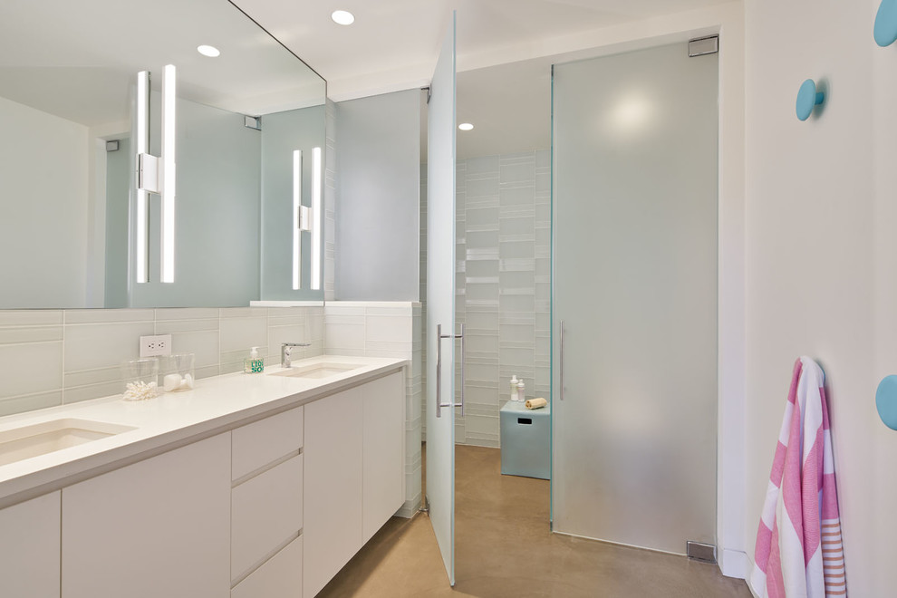 Exemple d'une salle de bain tendance avec un placard à porte plane, des portes de placard blanches, un carrelage blanc, un carrelage en pâte de verre, un mur blanc, un lavabo encastré, un sol beige et une cabine de douche à porte battante.