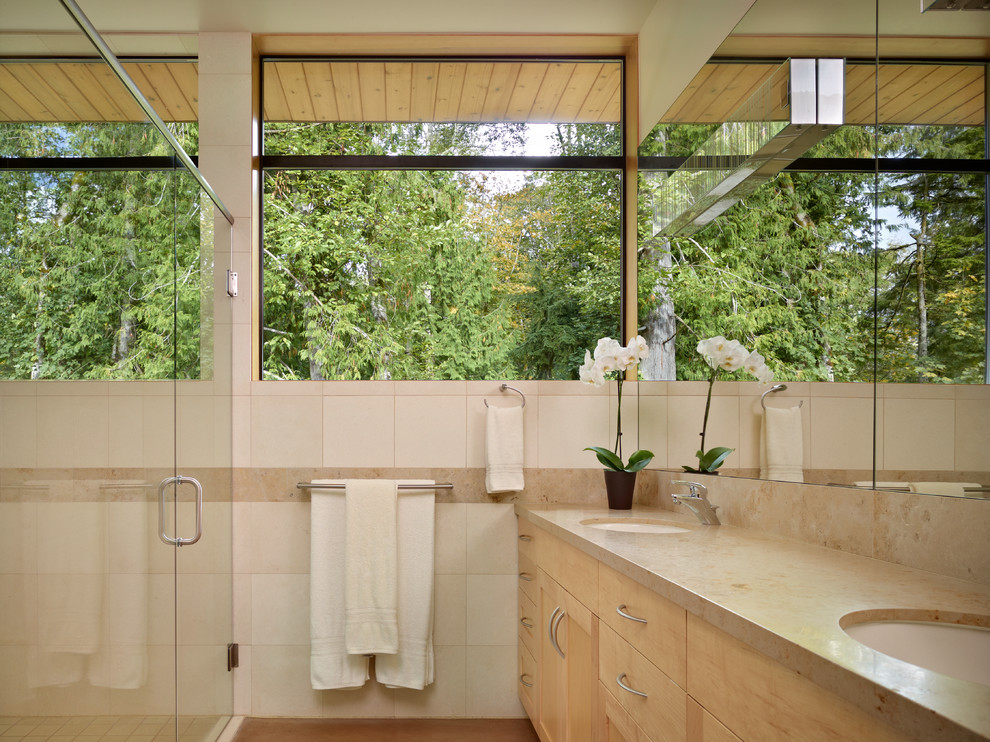 Esempio di una stanza da bagno contemporanea con lavabo sottopiano, ante lisce, ante in legno chiaro e piastrelle beige