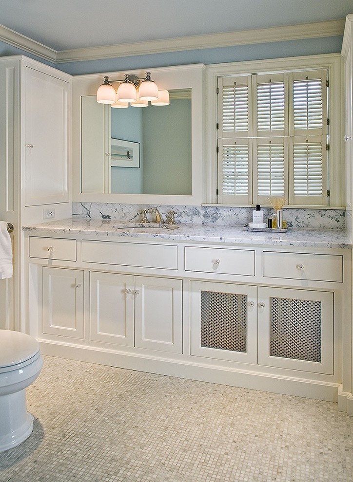 Esempio di una stanza da bagno classica di medie dimensioni con ante in stile shaker, ante bianche, WC a due pezzi, pareti blu, pavimento con piastrelle a mosaico, lavabo sottopiano e top in marmo