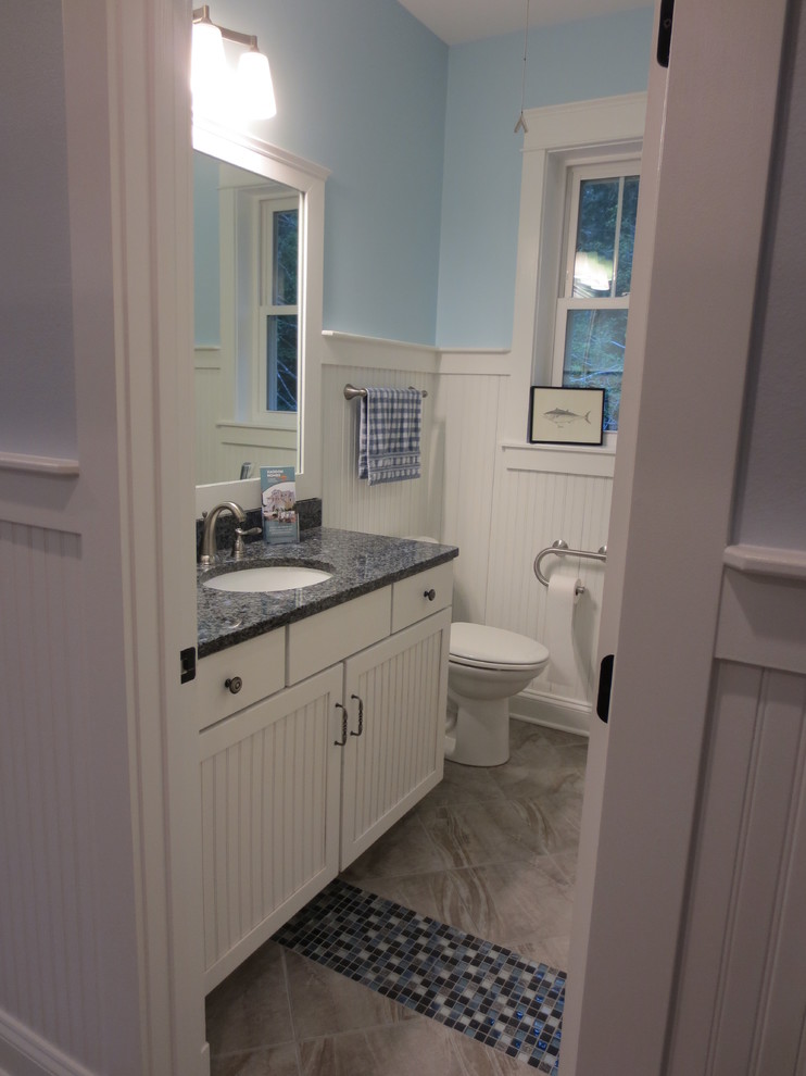 Réalisation d'une salle de bain marine avec un lavabo encastré, un placard à porte affleurante, des portes de placard blanches, un plan de toilette en granite, WC séparés et un carrelage bleu.