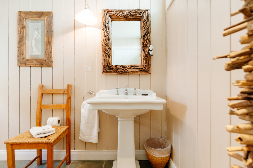 На фото: ванная комната в морском стиле с раковиной с пьедесталом и бежевыми стенами с