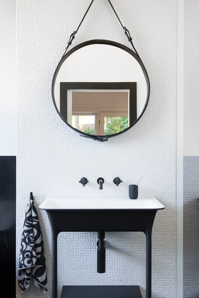 Cette image montre une petite salle de bain principale minimaliste avec un placard à porte plane, des portes de placard noires, une baignoire indépendante, une douche ouverte, WC suspendus, un carrelage blanc, du carrelage en marbre, un mur blanc, un sol en marbre, un lavabo de ferme, un sol noir et aucune cabine.