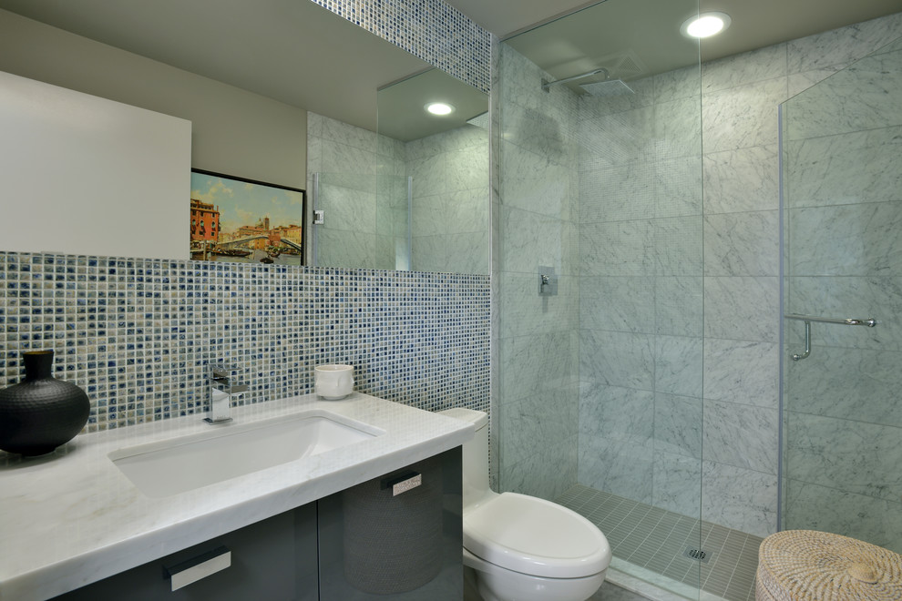 Bild på ett funkis en-suite badrum, med släta luckor, svarta skåp, ett badkar i en alkov, en dusch/badkar-kombination, en toalettstol med separat cisternkåpa, grå väggar, ett undermonterad handfat, marmorbänkskiva och dusch med skjutdörr
