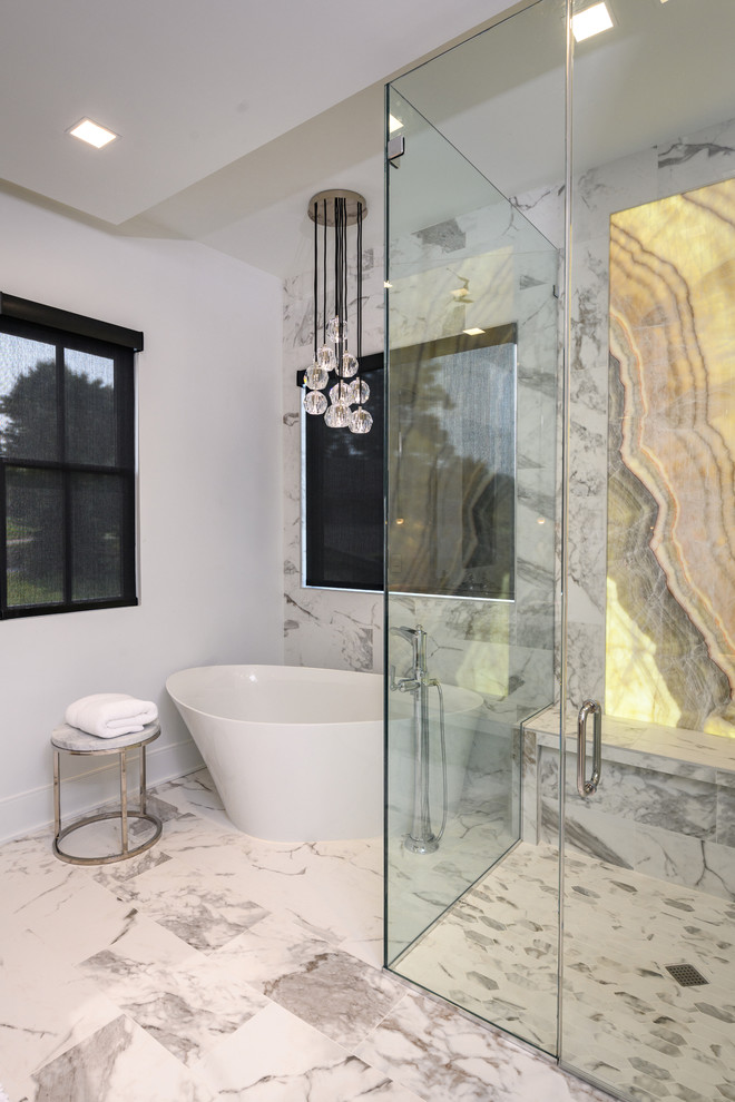 На фото: главная ванная комната в современном стиле с отдельно стоящей ванной, душем без бортиков, белой плиткой, мраморной плиткой, мраморным полом, белым полом, душем с распашными дверями и окном с