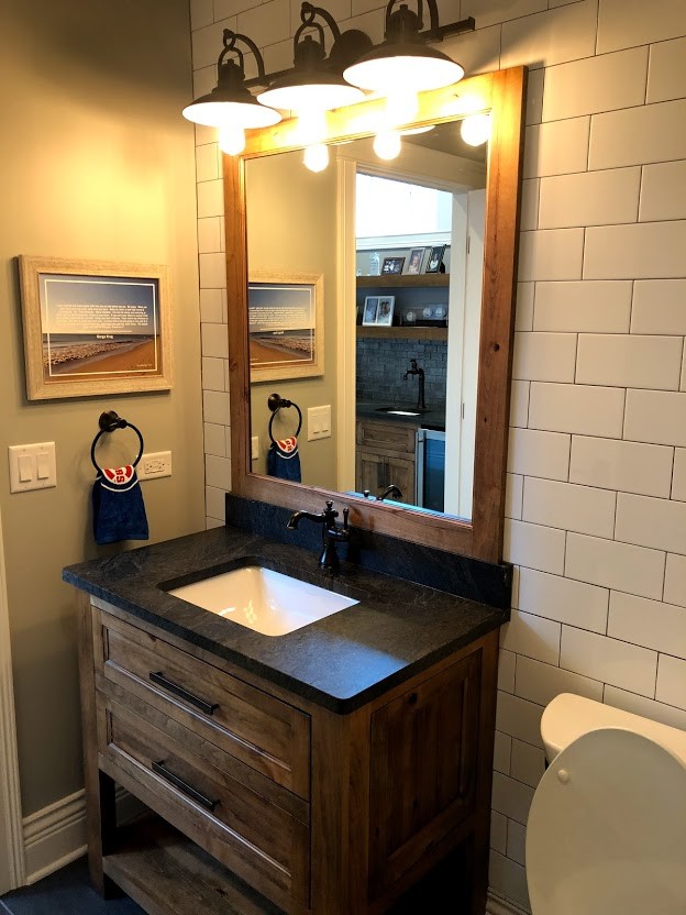 Small country bathroom in Chicago with shaker cabinets, dark wood cabinets, a two-piece toilet, white tiles, metro tiles, grey walls, ceramic flooring, a built-in sink, quartz worktops, blue floors and black worktops.