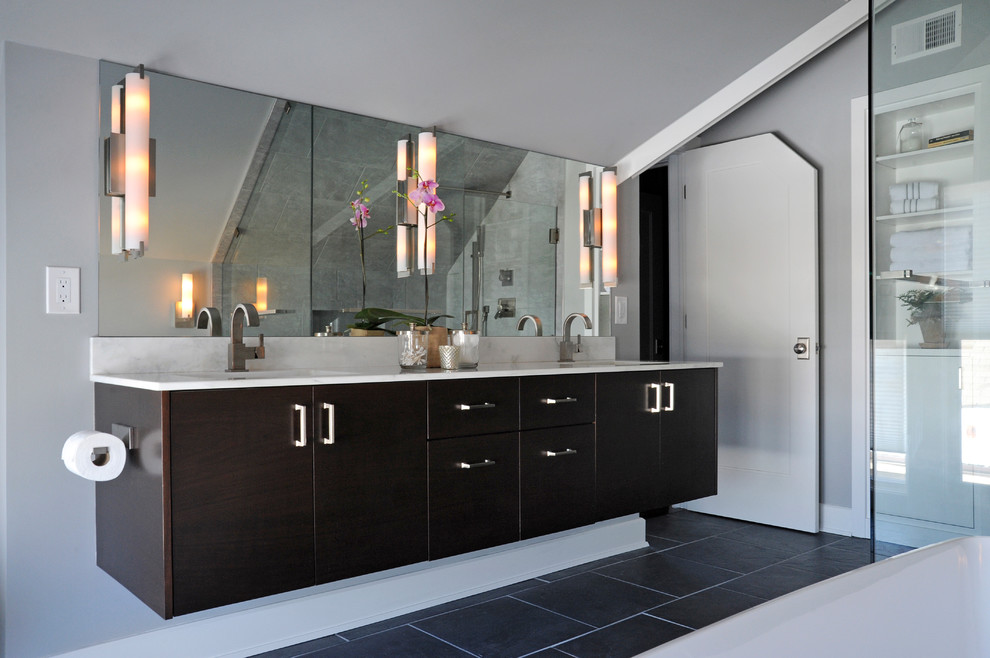 Cette photo montre une salle de bain principale moderne de taille moyenne avec des portes de placard noires, une baignoire indépendante, une douche d'angle, un carrelage gris, des carreaux de porcelaine, un mur blanc, un sol en ardoise, un lavabo encastré et un plan de toilette en quartz modifié.