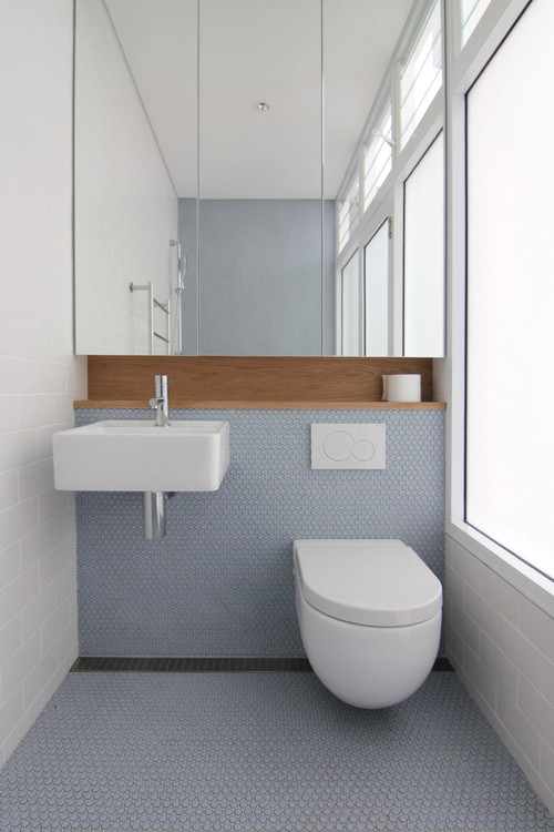 Soft Blue Touch: Light Blue Wall and Floor Tiles with Wood Niche