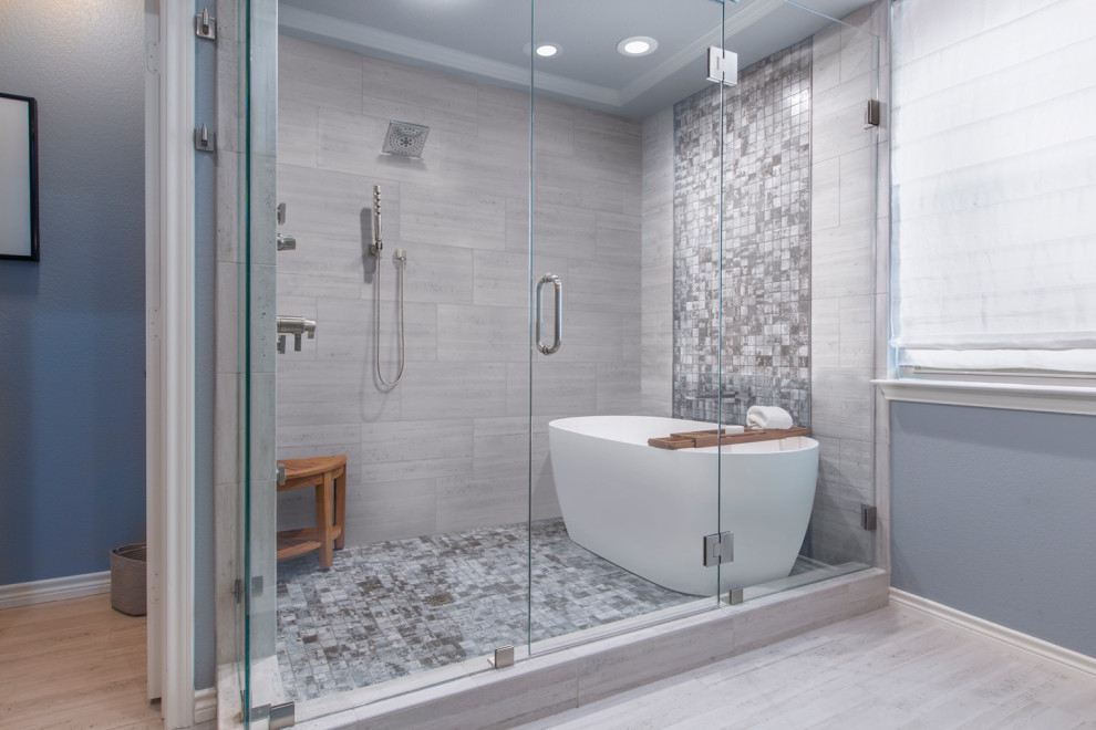Inspiration for a medium sized contemporary ensuite wet room bathroom in Other with shaker cabinets, white cabinets, a freestanding bath, a two-piece toilet, grey tiles, porcelain tiles, grey walls, porcelain flooring, a submerged sink, beige floors, a hinged door and grey worktops.