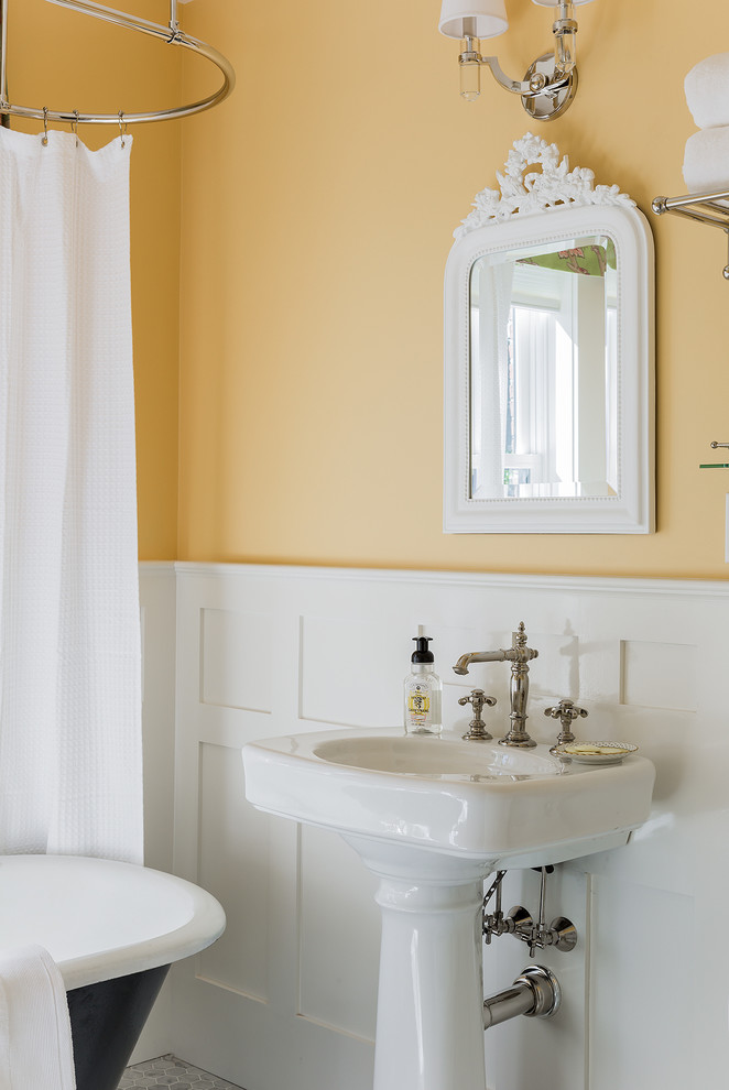 Inspiration för mellanstora klassiska badrum med dusch, med ett piedestal handfat, ett badkar med tassar, en dusch/badkar-kombination, en toalettstol med separat cisternkåpa, grå kakel, stenkakel, mosaikgolv, gula väggar, grått golv och dusch med duschdraperi