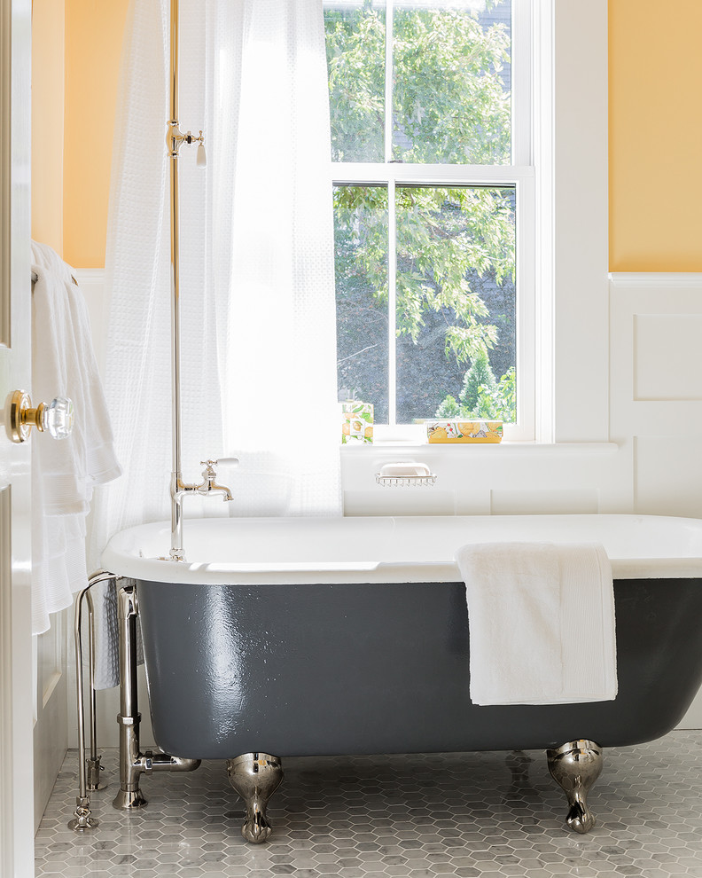 На фото: ванная комната среднего размера в классическом стиле с раковиной с пьедесталом, белыми фасадами, ванной на ножках, душем над ванной, раздельным унитазом, серой плиткой, желтыми стенами, мраморным полом, душевой кабиной и серым полом