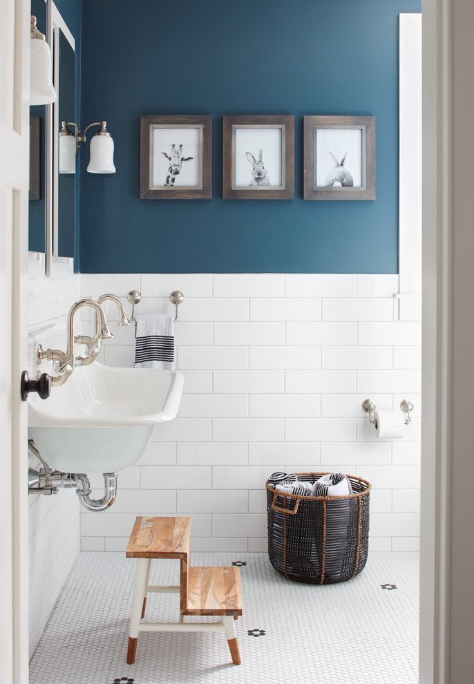Inredning av ett lantligt badrum, med blå väggar, mosaikgolv och ett avlångt handfat