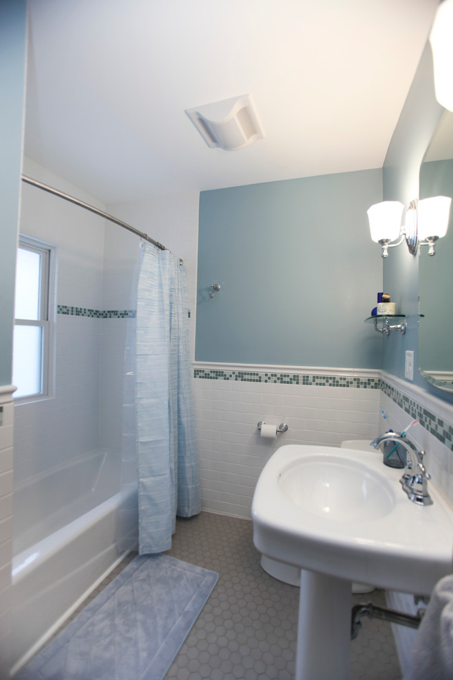 Modelo de cuarto de baño clásico de tamaño medio con lavabo con pedestal, bañera empotrada, combinación de ducha y bañera, baldosas y/o azulejos blancos, baldosas y/o azulejos de cerámica, paredes azules y suelo de baldosas de porcelana