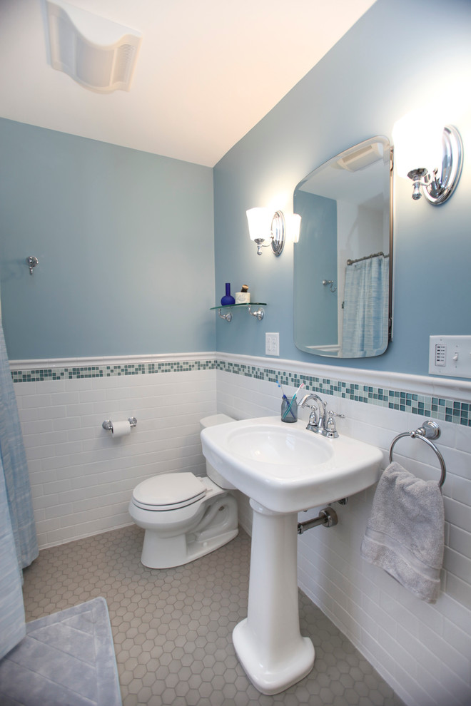 Ispirazione per una stanza da bagno chic di medie dimensioni con lavabo a colonna, WC a due pezzi, piastrelle bianche, piastrelle in ceramica, pareti blu e pavimento in gres porcellanato