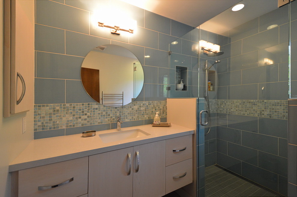 Esempio di una stanza da bagno minimalista con ante lisce, ante in legno chiaro, doccia ad angolo, pareti blu e lavabo sottopiano