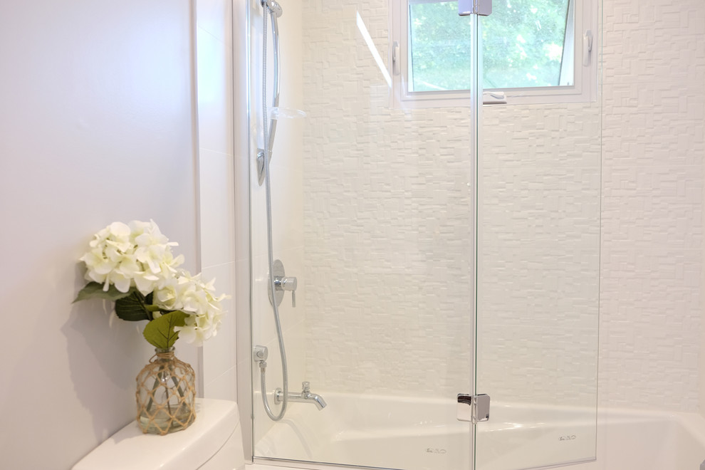 Bild på ett litet funkis en-suite badrum, med släta luckor, vita skåp, ett badkar i en alkov, en dusch/badkar-kombination, en toalettstol med hel cisternkåpa, vit kakel, porslinskakel, grå väggar, klinkergolv i porslin, ett undermonterad handfat och bänkskiva i akrylsten