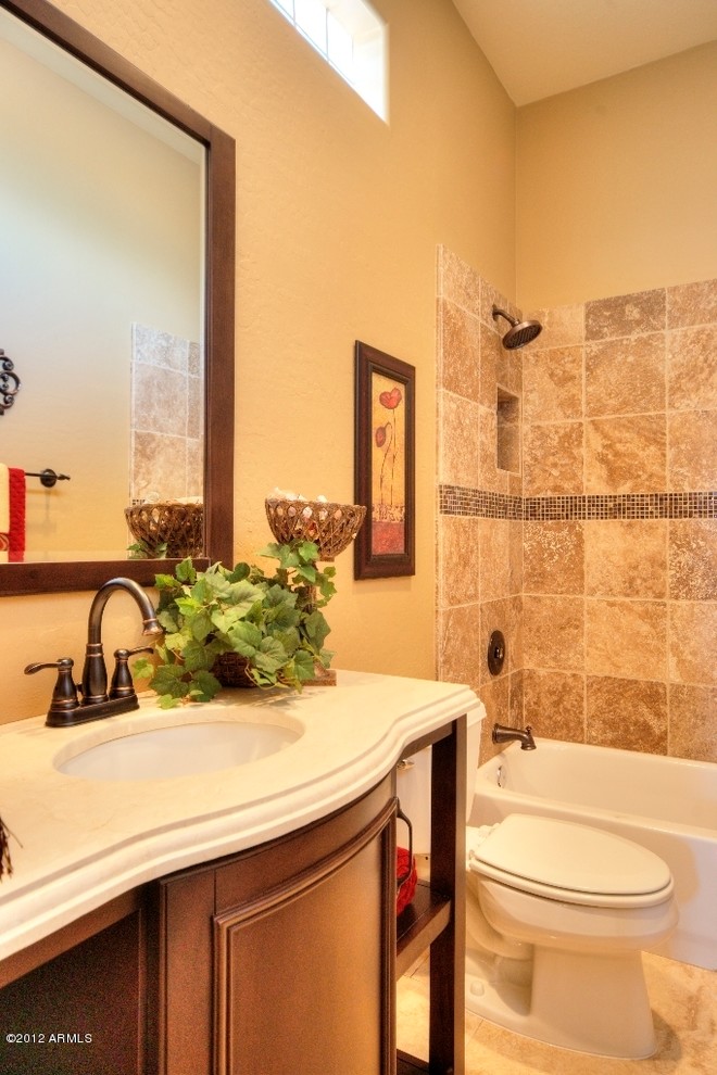 Mid-sized mountain style beige tile and ceramic tile ceramic tile bathroom photo in Phoenix with an undermount sink, beaded inset cabinets, medium tone wood cabinets, granite countertops and beige walls