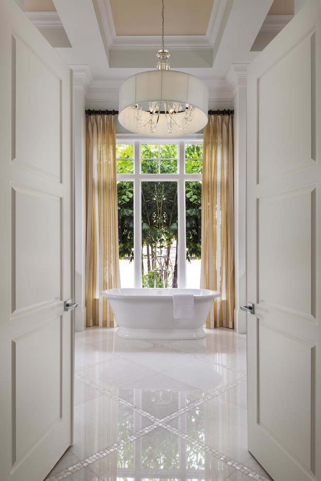 Foto de cuarto de baño principal tradicional extra grande con bañera exenta, suelo de mármol y suelo blanco