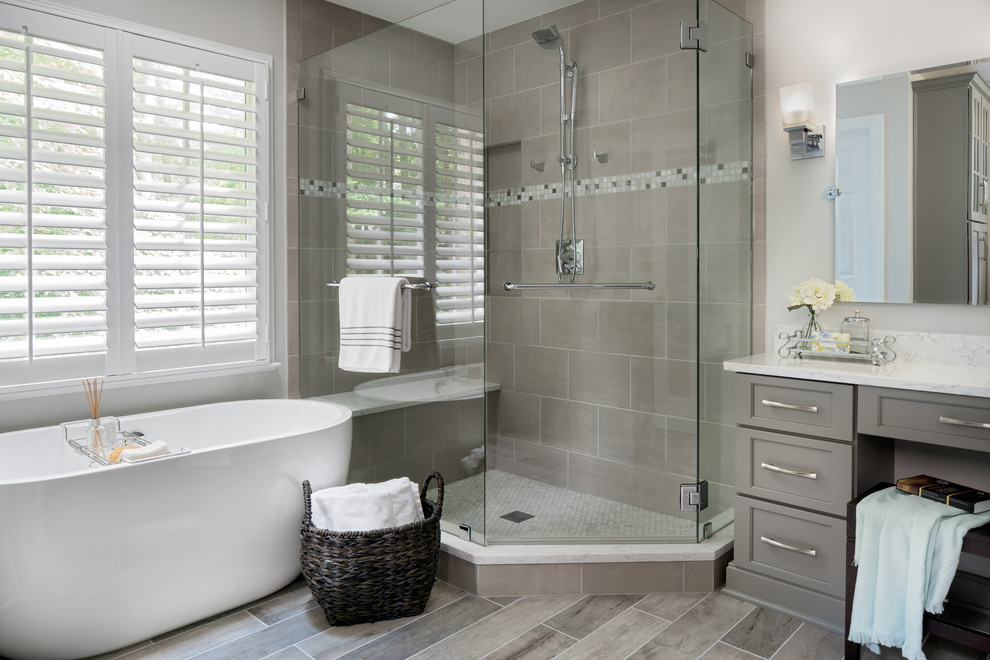 Example of a mid-sized transitional master gray tile and ceramic tile porcelain tile and gray floor bathroom design in Charlotte with recessed-panel cabinets, gray cabinets, a one-piece toilet, white walls, an undermount sink, quartz countertops and a hinged shower door