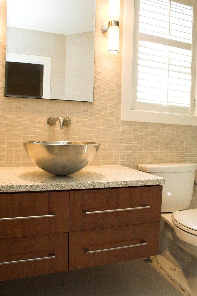 Inspiration for a contemporary beige tile and porcelain tile bathroom remodel in DC Metro with a vessel sink, flat-panel cabinets, dark wood cabinets, quartz countertops and a two-piece toilet