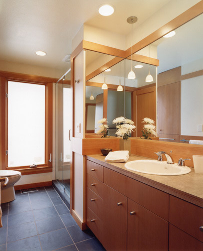 Exempel på ett mellanstort klassiskt badrum med dusch, med ett nedsänkt handfat, släta luckor, skåp i mellenmörkt trä, laminatbänkskiva, en dusch i en alkov, en toalettstol med separat cisternkåpa, svart kakel, stenkakel, beige väggar och skiffergolv