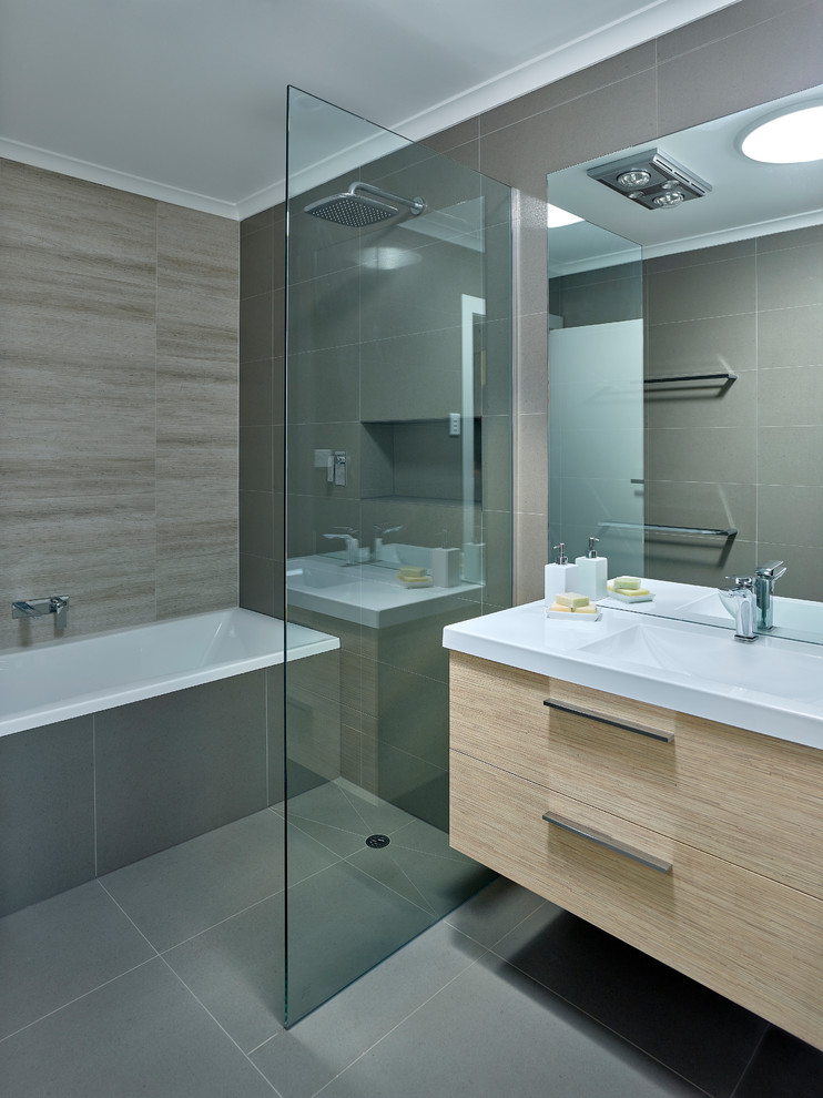 Foto de cuarto de baño principal actual pequeño con lavabo integrado, puertas de armario de madera clara, bañera encastrada, ducha abierta, baldosas y/o azulejos grises y paredes grises