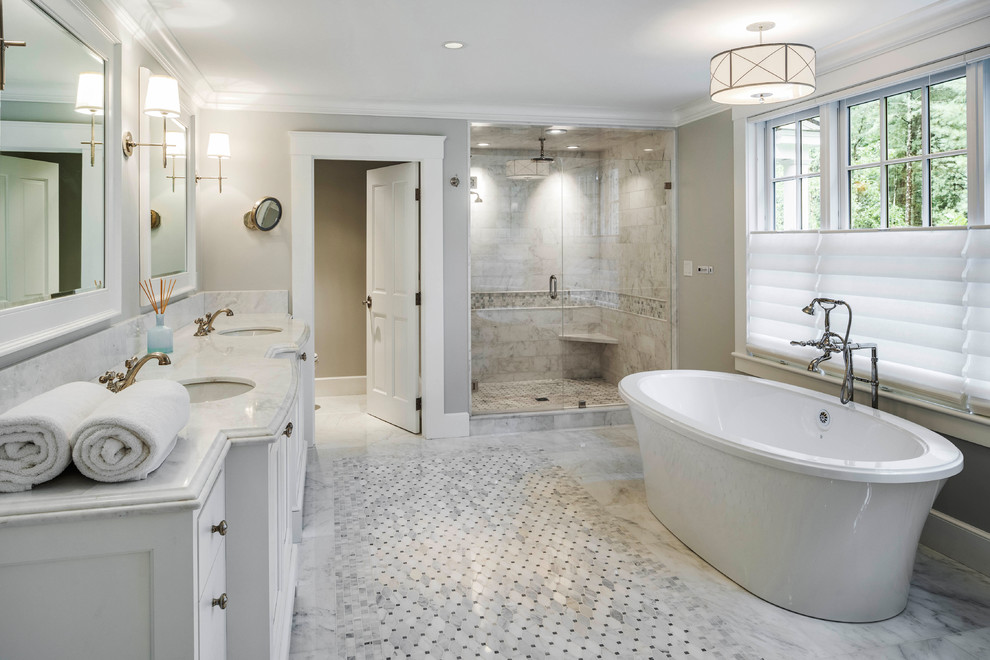 Пример оригинального дизайна: большая главная ванная комната в стиле неоклассика (современная классика) с белыми фасадами, отдельно стоящей ванной, керамической плиткой, серыми стенами, мраморным полом, врезной раковиной, мраморной столешницей, белым полом, душем с распашными дверями, белой столешницей, душем в нише и белой плиткой