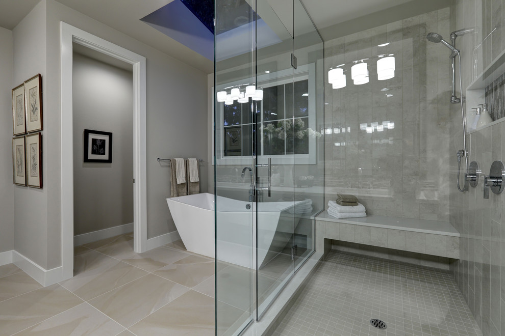 Foto di una stanza da bagno padronale minimalista di medie dimensioni con vasca freestanding, piastrelle grigie, pareti grigie, pavimento con piastrelle in ceramica e porta doccia a battente