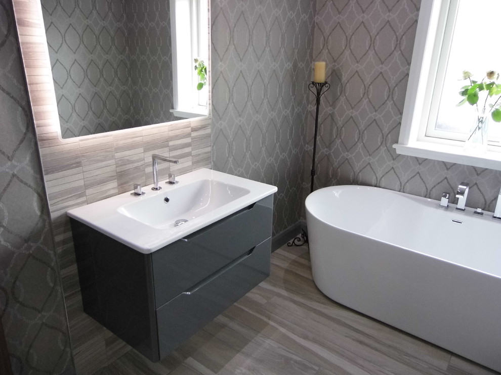 Ispirazione per una stanza da bagno design di medie dimensioni con vasca freestanding, piastrelle effetto legno e pareti grigie