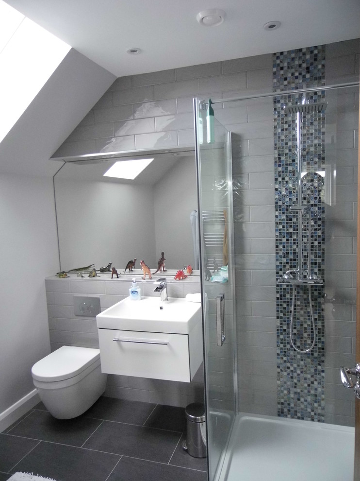 Immagine di una stanza da bagno per bambini design di medie dimensioni con doccia ad angolo, piastrelle grigie, piastrelle a mosaico, pareti grigie, pavimento in gres porcellanato e WC sospeso