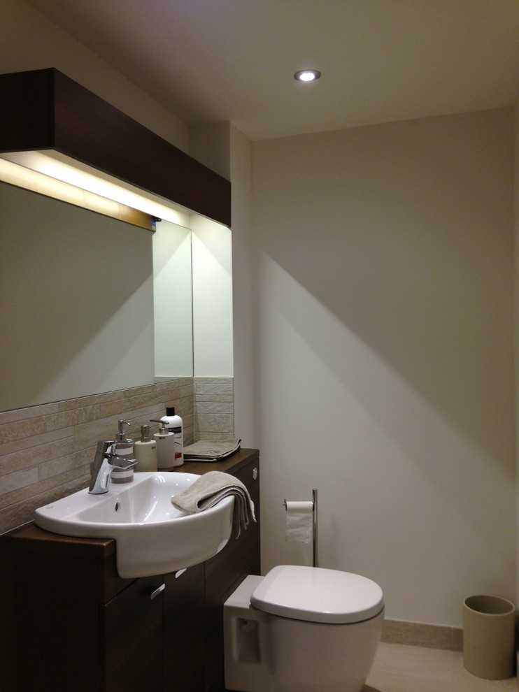 Bild på ett stort funkis badrum, med ett nedsänkt handfat, möbel-liknande, skåp i mörkt trä, träbänkskiva, en dusch/badkar-kombination, en vägghängd toalettstol, grå kakel, porslinskakel, beige väggar och klinkergolv i porslin