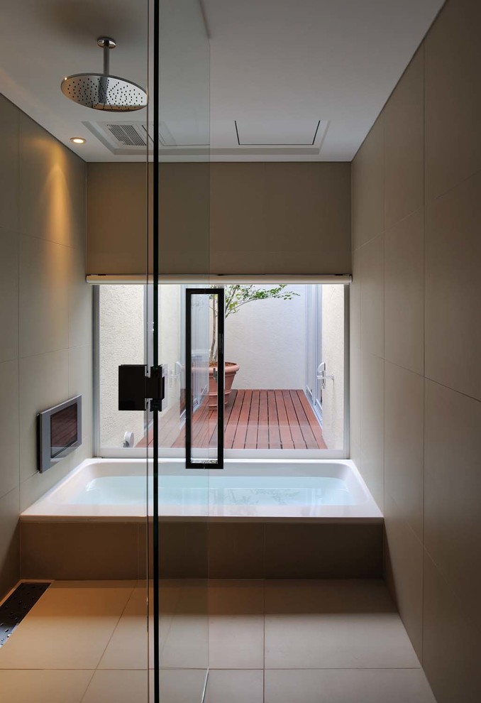 大阪にあるコンテンポラリースタイルのおしゃれな浴室 (ドロップイン型浴槽、シャワー付き浴槽	、ベージュのタイル、セラミックタイル、ベージュの壁、セラミックタイルの床) の写真