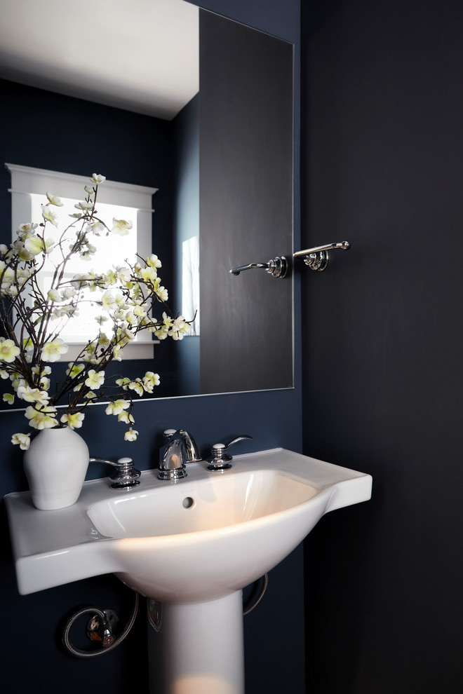 Foto på ett mellanstort amerikanskt badrum med dusch, med en toalettstol med hel cisternkåpa, blå väggar, mörkt trägolv, ett piedestal handfat och brunt golv