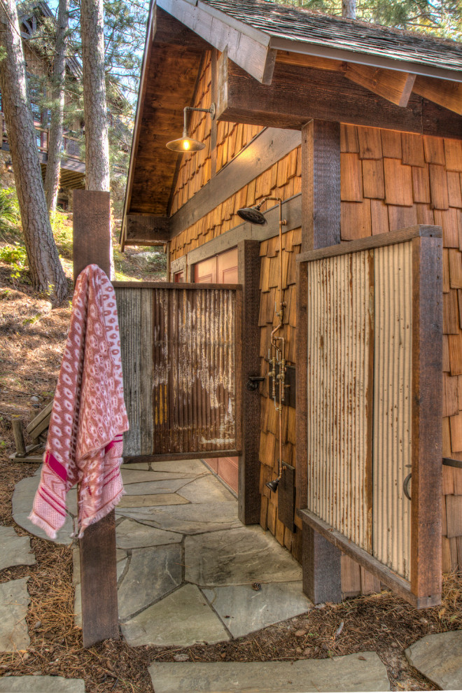 Idée de décoration pour une petite salle de bain chalet en bois avec une douche ouverte, une vasque et une cabine de douche à porte battante.