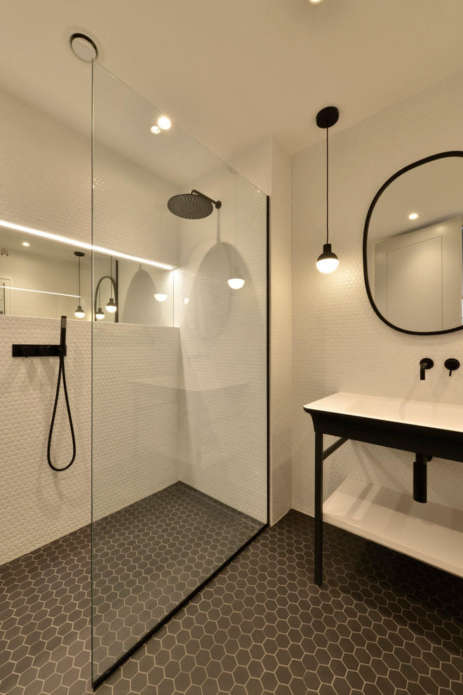 Идея дизайна: ванная комната в стиле модернизм с фасадами островного типа, черными фасадами, открытым душем, инсталляцией, черно-белой плиткой, керамической плиткой, белыми стенами, полом из керамогранита, раковиной с пьедесталом, черным полом, открытым душем и белой столешницей