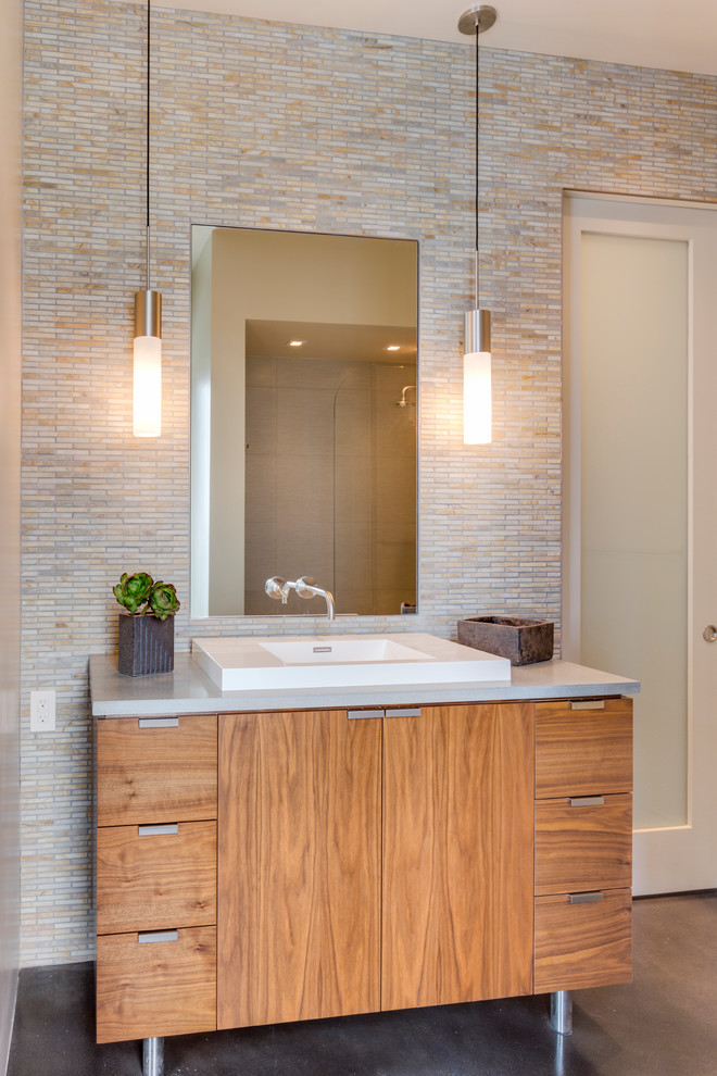 Aménagement d'une salle de bain contemporaine en bois brun avec un lavabo posé, un placard à porte plane, mosaïque, sol en béton ciré et un carrelage beige.