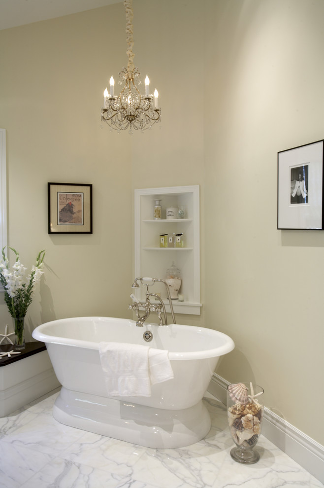 Modelo de cuarto de baño clásico grande con bañera exenta, lavabo encastrado, encimera de mármol, ducha empotrada, baldosas y/o azulejos de piedra, paredes beige y suelo de mármol