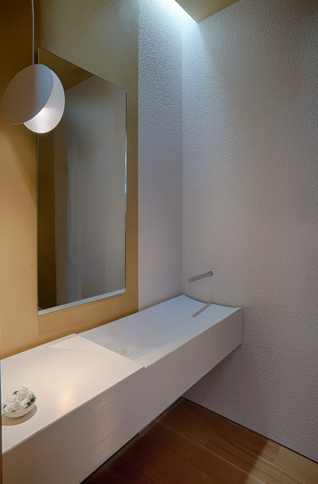 Cette photo montre une grande salle d'eau moderne avec un carrelage blanc, une grande vasque, un plan de toilette en béton, un sol marron et un plan de toilette blanc.