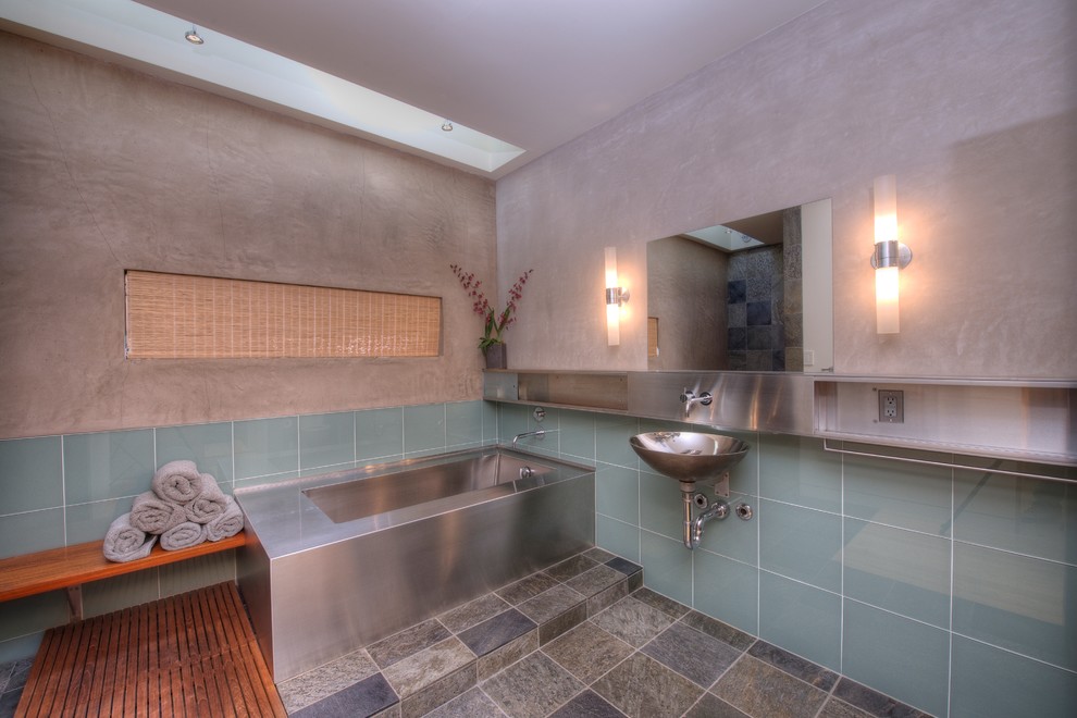 Diseño de cuarto de baño actual con bañera esquinera, baldosas y/o azulejos grises, baldosas y/o azulejos de vidrio, lavabo suspendido y paredes grises