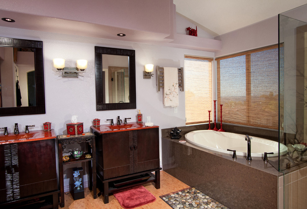На фото: большая главная ванная комната в восточном стиле с монолитной раковиной, фасадами островного типа, темными деревянными фасадами, стеклянной столешницей, накладной ванной, угловым душем, унитазом-моноблоком, разноцветной плиткой, керамогранитной плиткой, фиолетовыми стенами и полом из бамбука с