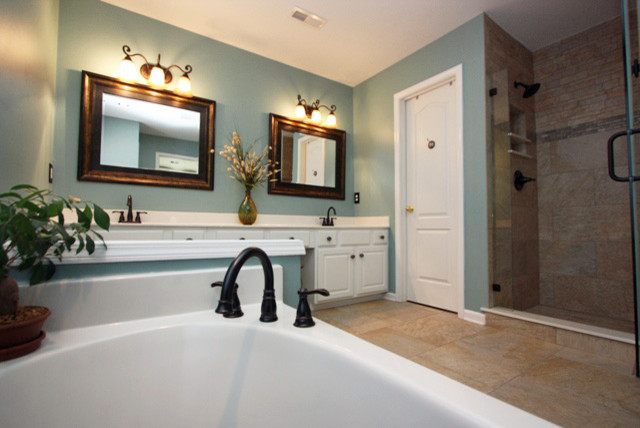 Example of a large classic beige tile and porcelain tile porcelain tile bathroom design in Raleigh with an integrated sink, raised-panel cabinets, white cabinets, solid surface countertops, a two-piece toilet and blue walls