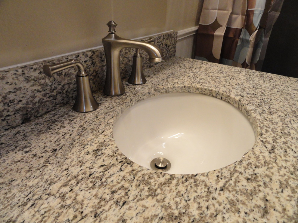 Elegant bathroom photo in Cedar Rapids with an undermount sink, raised-panel cabinets, white cabinets and granite countertops