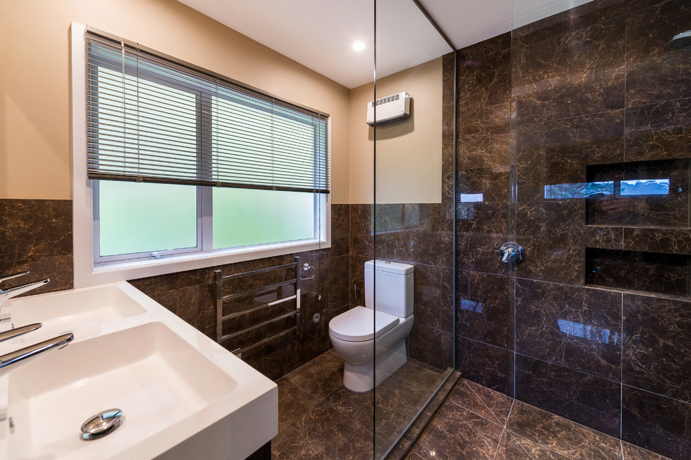 Modernes Badezimmer En Suite mit braunen Schränken, Nasszelle, Toilette mit Aufsatzspülkasten, braunen Fliesen, Keramikfliesen, beiger Wandfarbe und Keramikboden in Sonstige