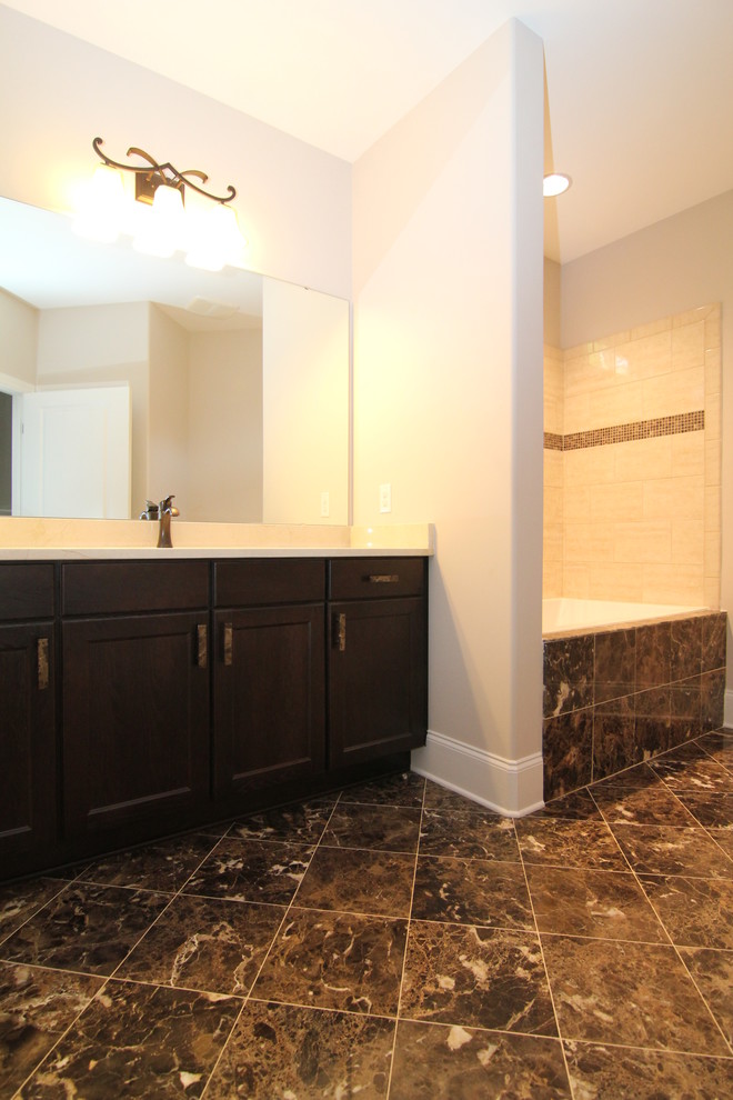 Inspiration for a mid-sized timeless brown tile and ceramic tile ceramic tile bathroom remodel in Raleigh with an undermount sink, recessed-panel cabinets, dark wood cabinets, a one-piece toilet and gray walls