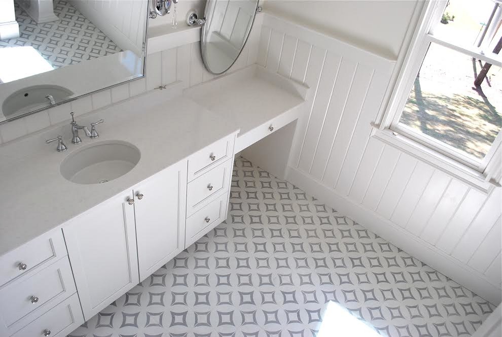 Lantlig inredning av ett mellanstort badrum med dusch, med luckor med infälld panel, vita skåp, bänkskiva i kvarts, vita väggar, ett undermonterad handfat och vitt golv