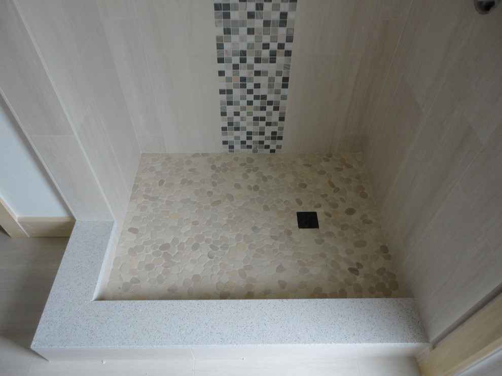 Cette image montre une petite salle de bain principale design avec un carrelage blanc, des carreaux de porcelaine, une douche ouverte et un sol en galet.